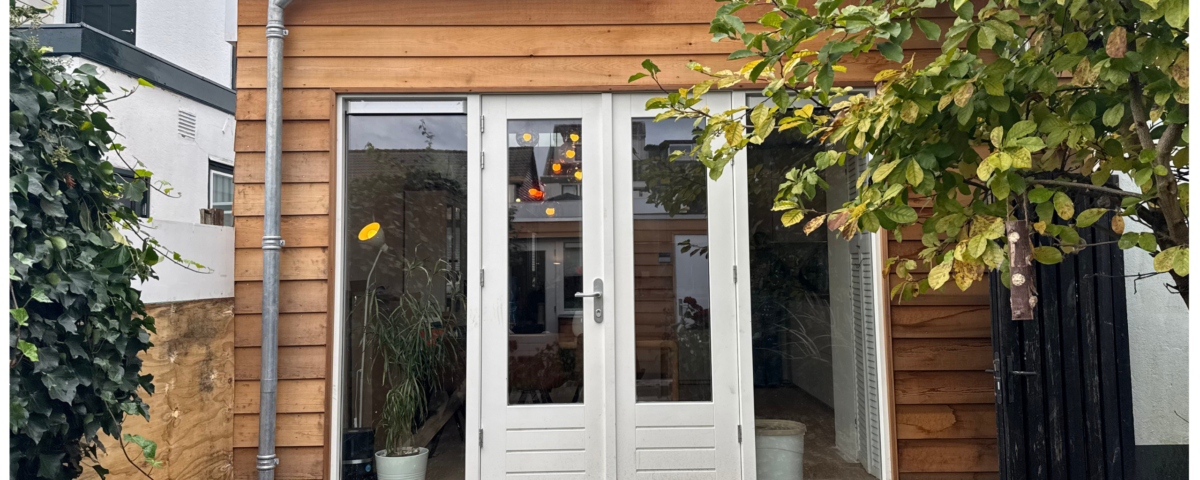 Uitbouw met houten gevelbekleding en openslaande deuren, gerealiseerd door Vastgoed Groep inclusief vloerverwarming en keukenrenovatie